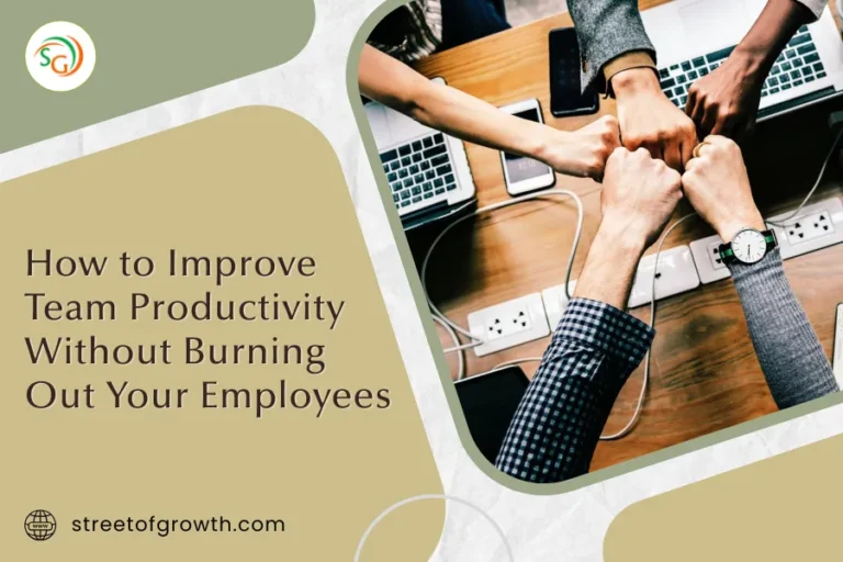 Team members doing a fist bump over a shared workspace with laptops, symbolizing collaboration and motivation, representing how to improve team productivity without burning out your employees.