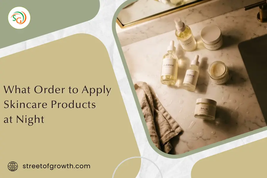 Overhead view of various skincare bottles and a towel on a wet marble counter, illustrating what order to apply skincare products at night.