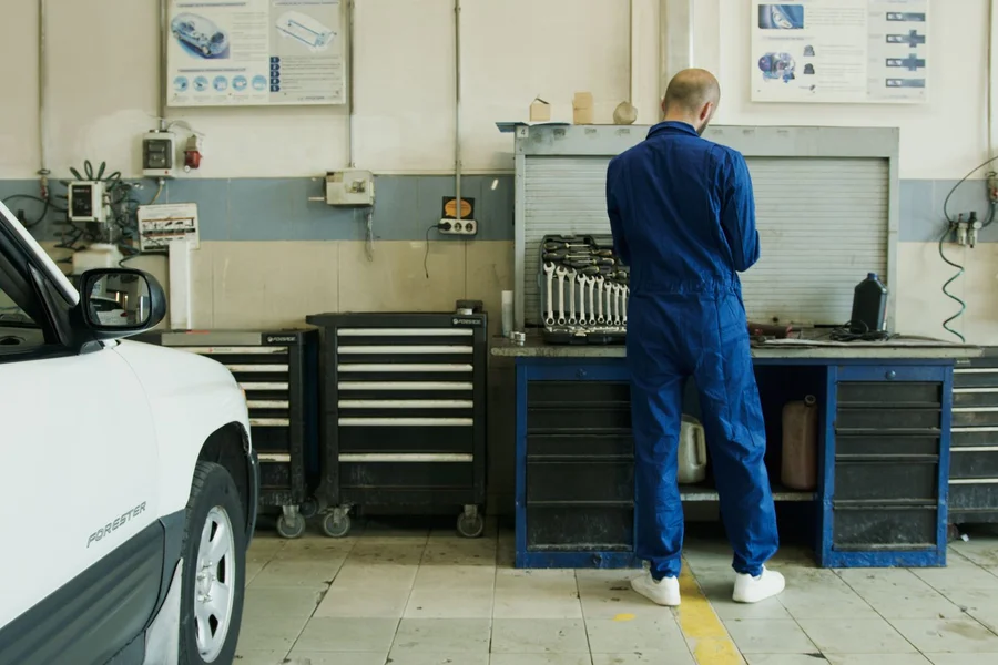 Vehicle health report on tablet Technician reviewing vehicle health scan report on digital tablet near open car hood