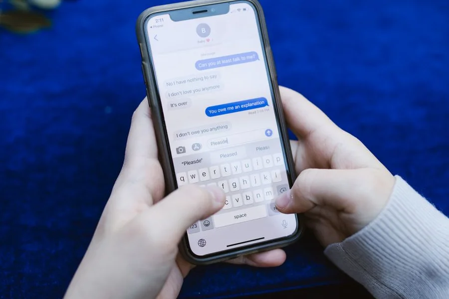 Customer booking via chat Customer texting on smartphone to book an auto repair appointment through AI chat
