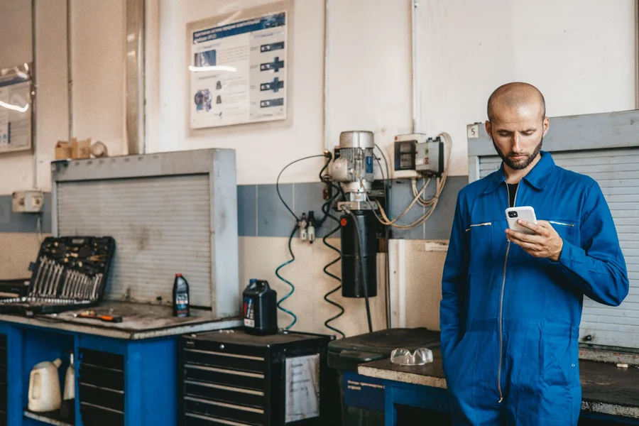 Mechanic handling customer call Mechanic talking to customer on phone while working in an auto repair shop