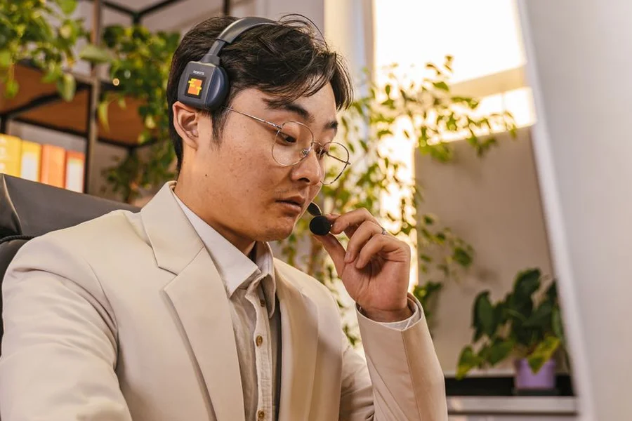Customer service worker at a headset desk handling a scheduling call in an office