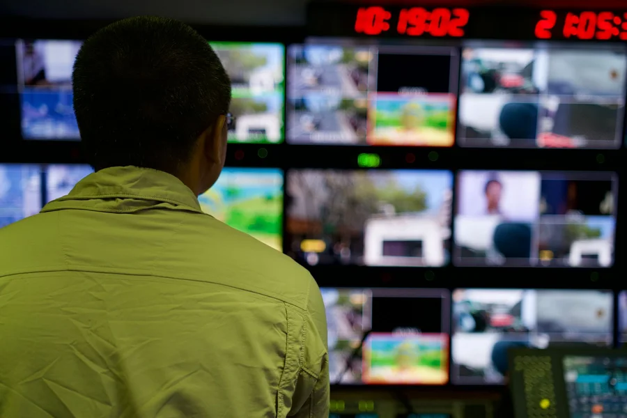 Alarm Monitoring Station Security operator watching multiple CCTV monitors in a monitoring station