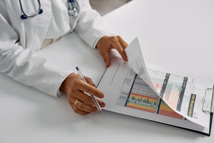 Clinician reviewing patient medical records on a computer screen at a desk