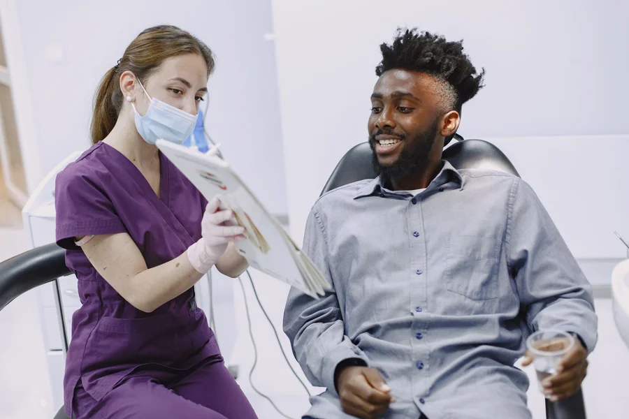 Reviewing Findings With Patient Dentist discussing x-ray findings and treatment options with a patient in the chair