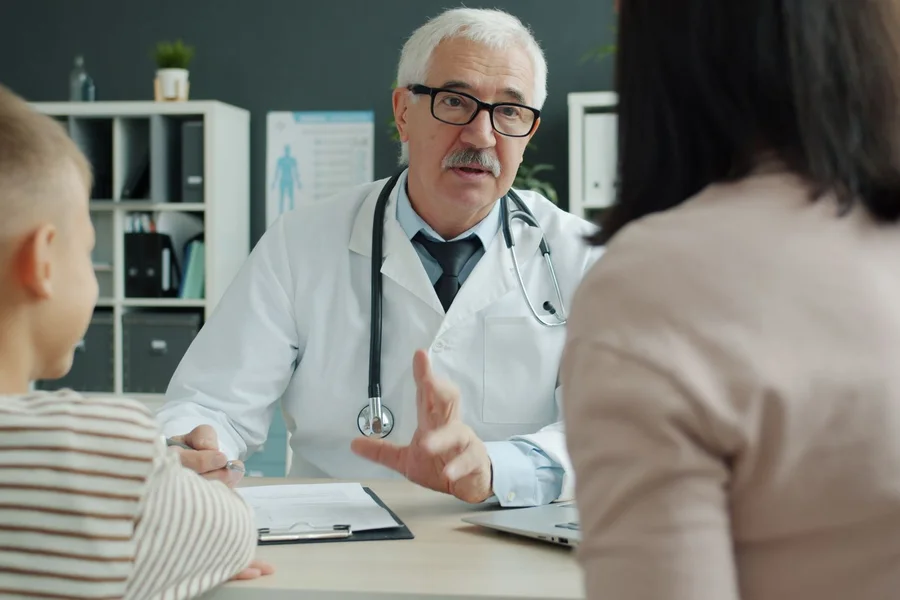 Doctor speaking with a patient during a clinical consultation in an exam room