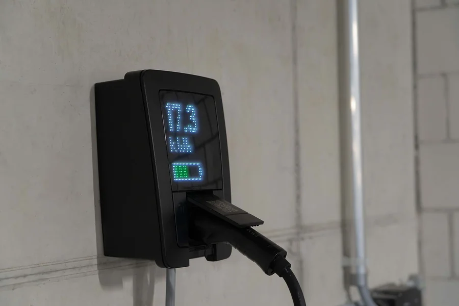 EV home charging station Electric vehicle plugged into a charging station in a home garage