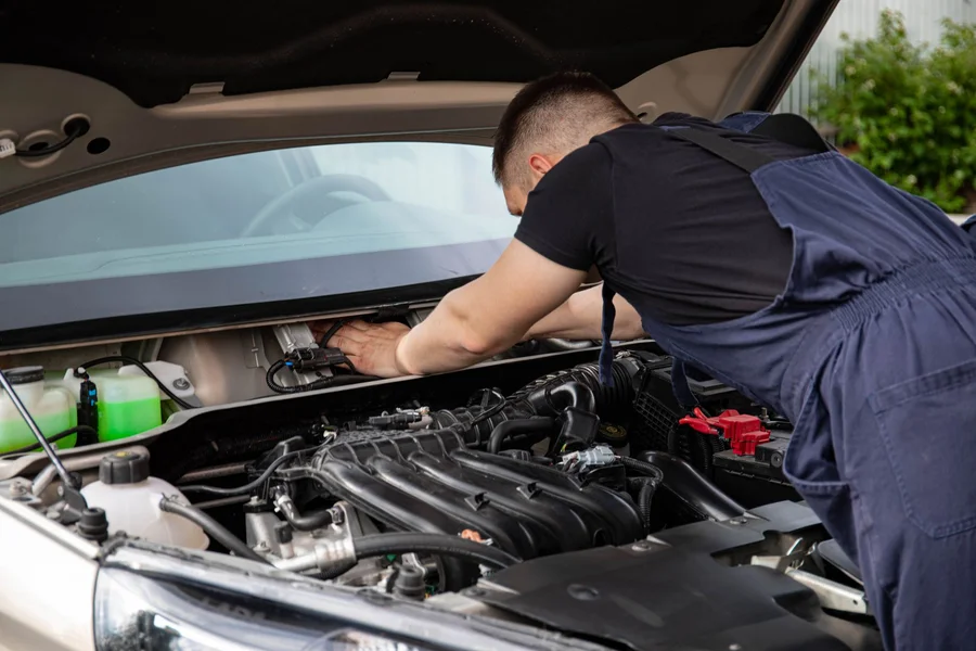 Mobile mechanic driveway repair Mobile mechanic repairing a car engine in a residential driveway service call