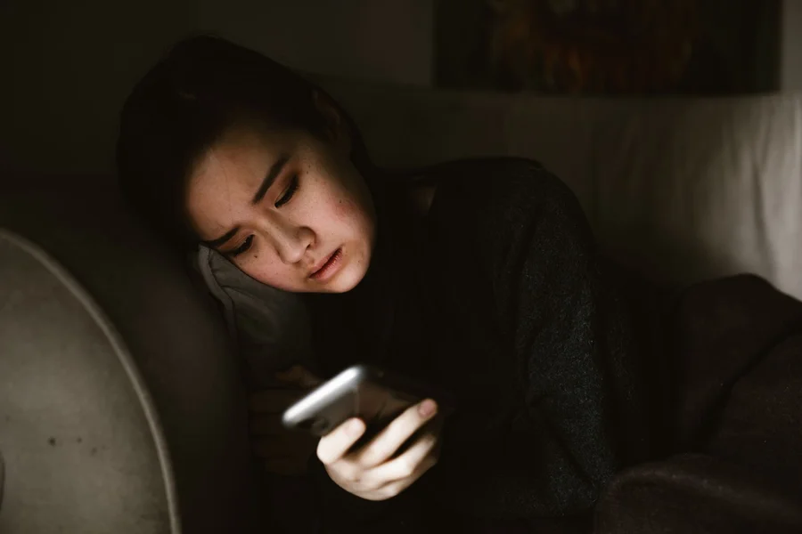 Night Check On App Parent checking a baby monitor app on a phone screen during the night