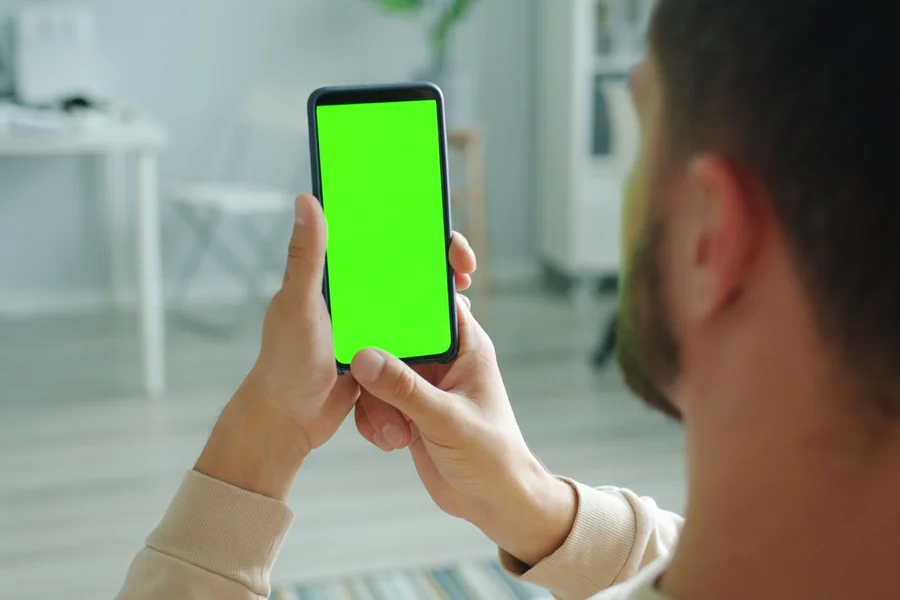Reviewing Camera Alerts Person reviewing home security camera alerts on a phone app indoors
