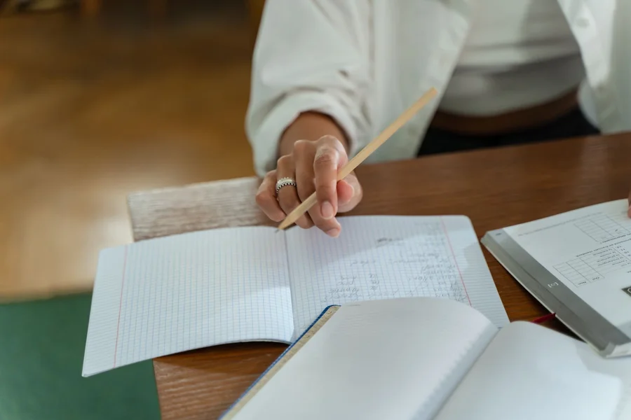 Student Practice Work Student working through printed practice problems with a pencil at a table
