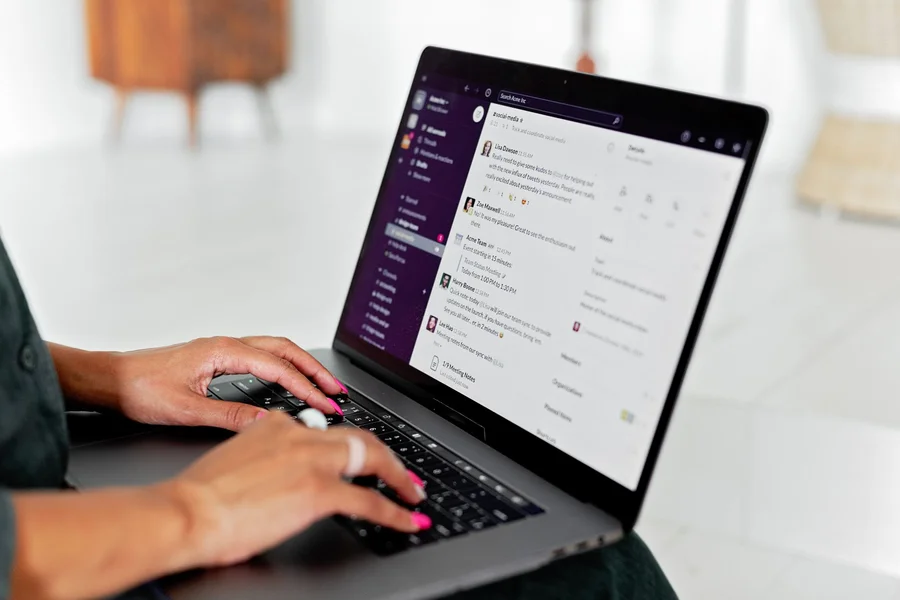 Always-on AI agents at work Person typing in a team chat app on a laptop
