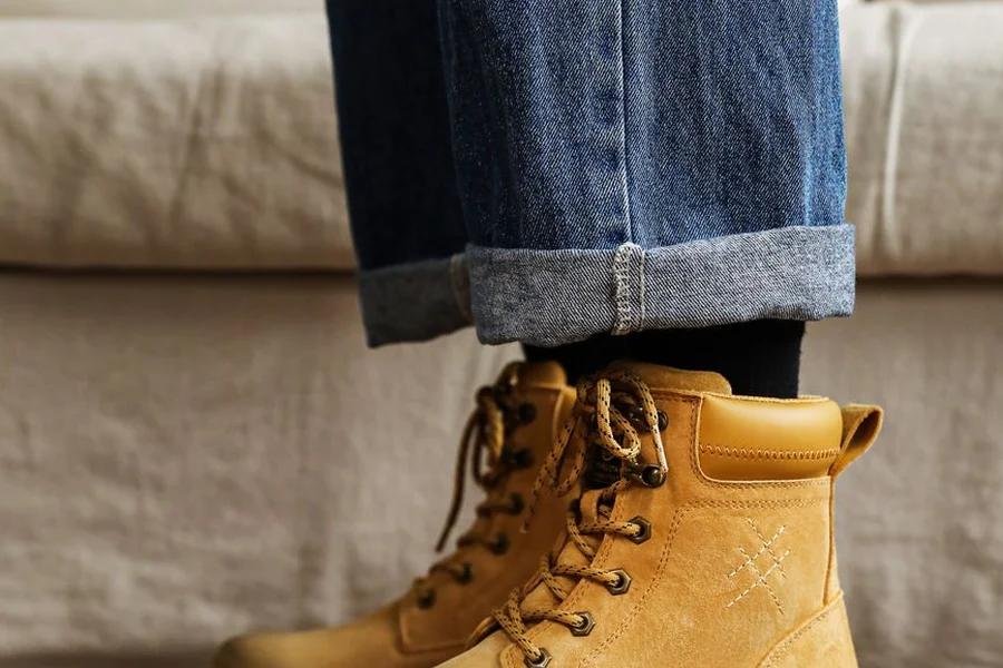 Brown leather ankle boots on a wooden floor, suited to wearing with cuffed jeans