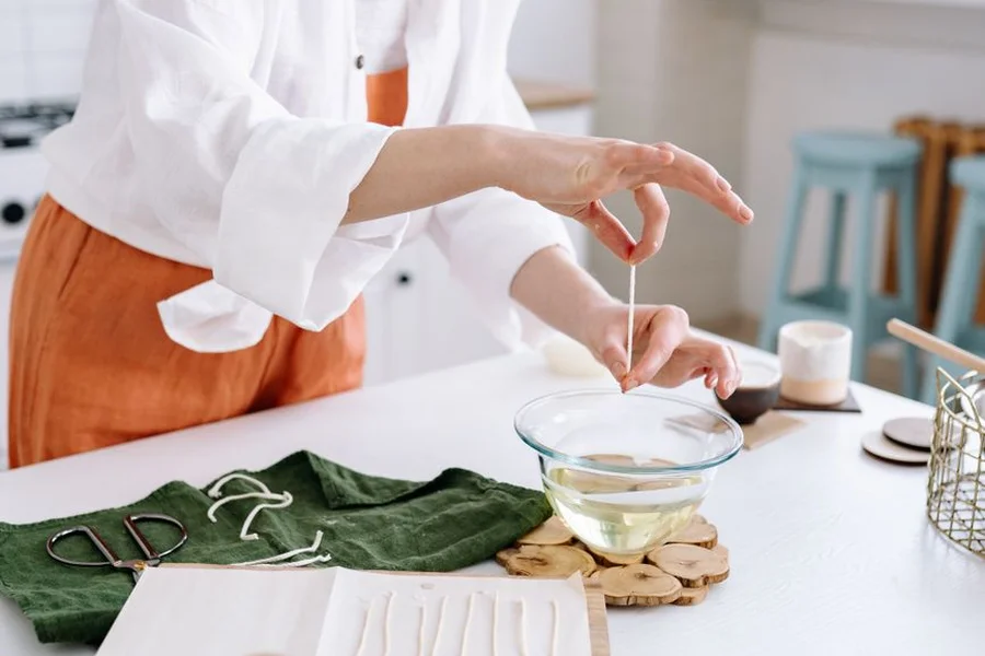 Artisan making handmade candles in a home workshop studio