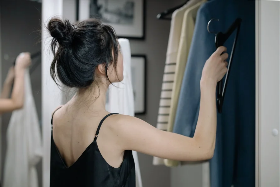 Woman choosing a smart casual interview outfit from her wardrobe at home