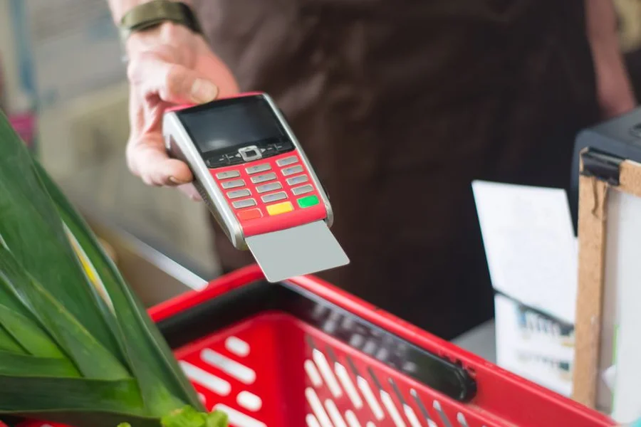 Paying From The Envelope Shopper paying with cash at a grocery store checkout using the envelope system