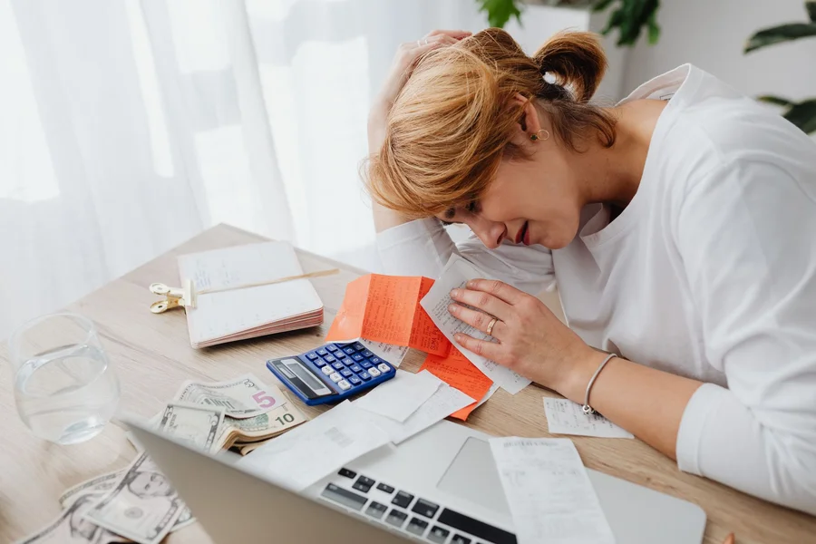 Person reviewing a bank statement and receipts to fill in a monthly budget worksheet