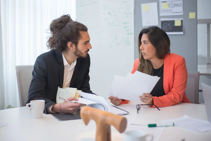 Two professionals reviewing company research together in a meeting room