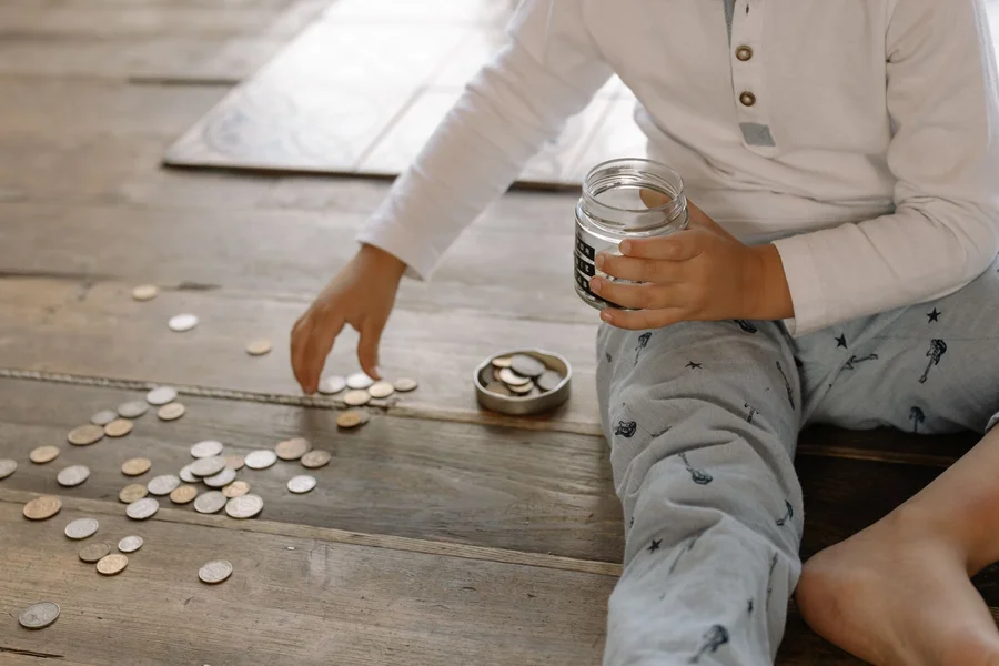 Coins collected in a glass savings jar as a small emergency fund buffer