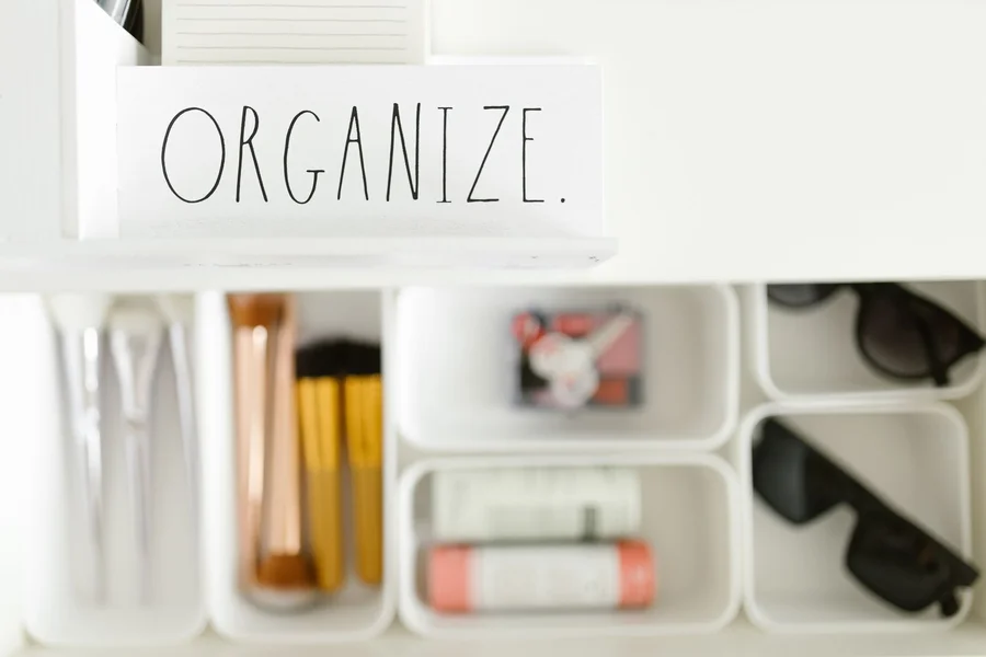 Clear plastic storage bins and drawer organizers used to organize under a bathroom sink