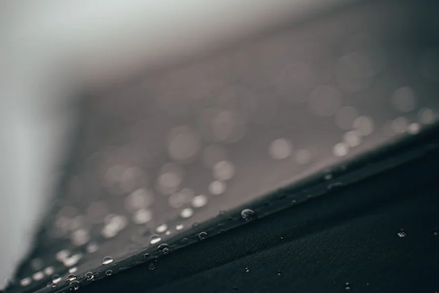 Water beading on treated fabric Close-up of water droplets beading on the surface of a treated jacket fabric