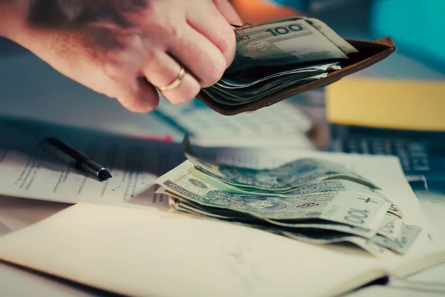 Planning Weekly Refills Wallet with cash and a notebook used to plan weekly cash envelope refills