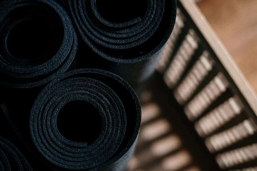 Comparing yoga mat thickness Close-up of rolled dark yoga mats showing their layered thickness